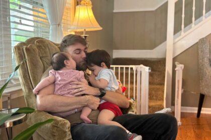 U.S. Marine Corps veteran Adrian Clouatre holds his 3-month-old daughter Lyn and his nearly 2-year-old son Noah at their home in Baton Rouge, Louisiana, June 17, 2025.